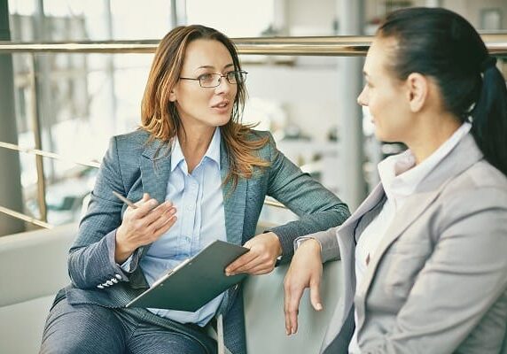 coach asking questions and listening to client on a couch