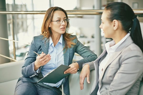 coach asking questions and listening to client on a couch