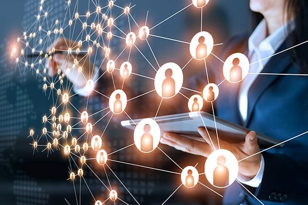 person working at a transparent screen with a map of many connected people icons signifying connecting with professionals on social media