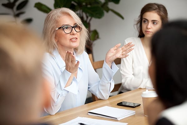 woman addressing a table of women in discussion